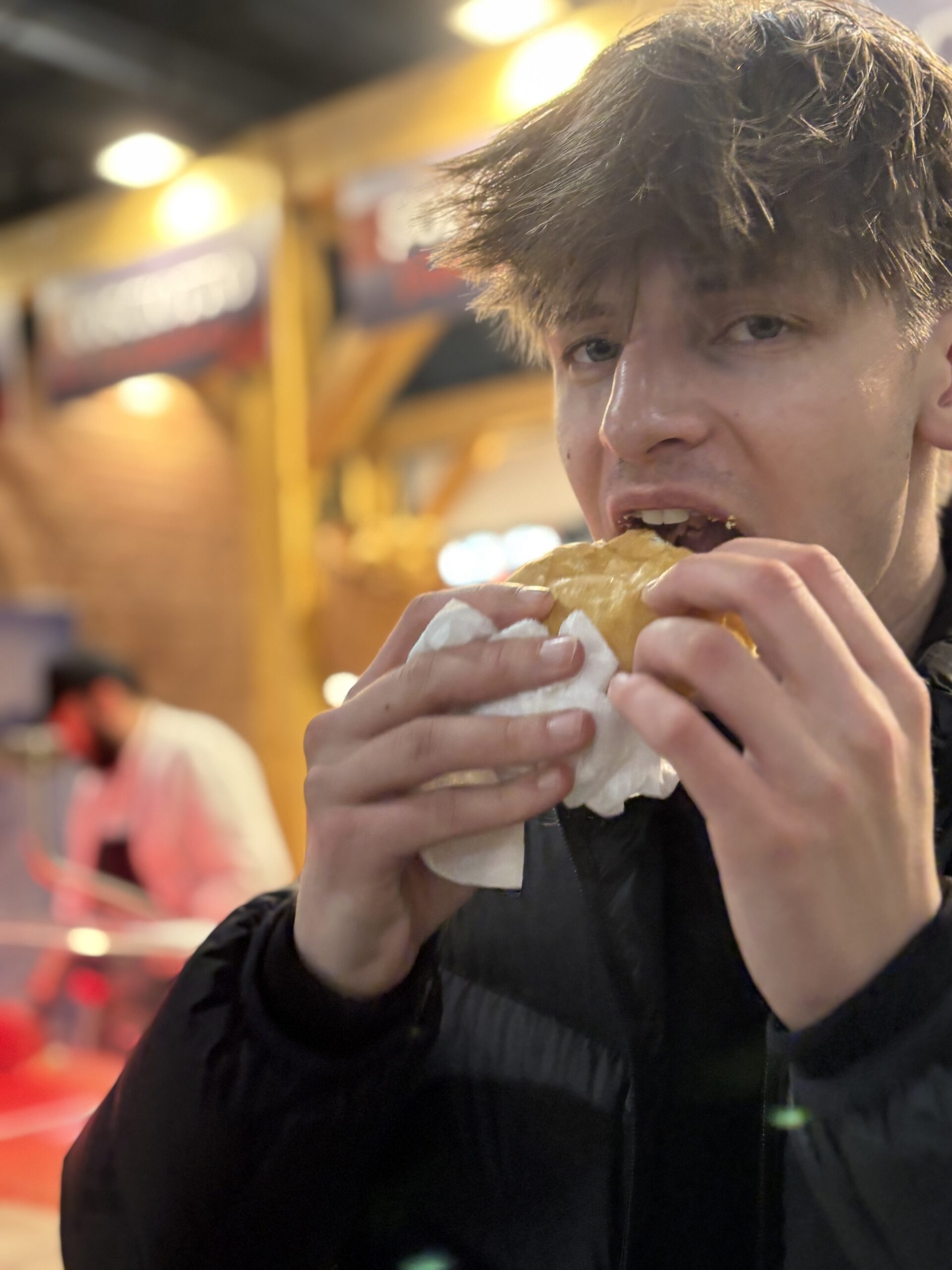 Ragazzo che addenta un panino al banco Sandalmazi